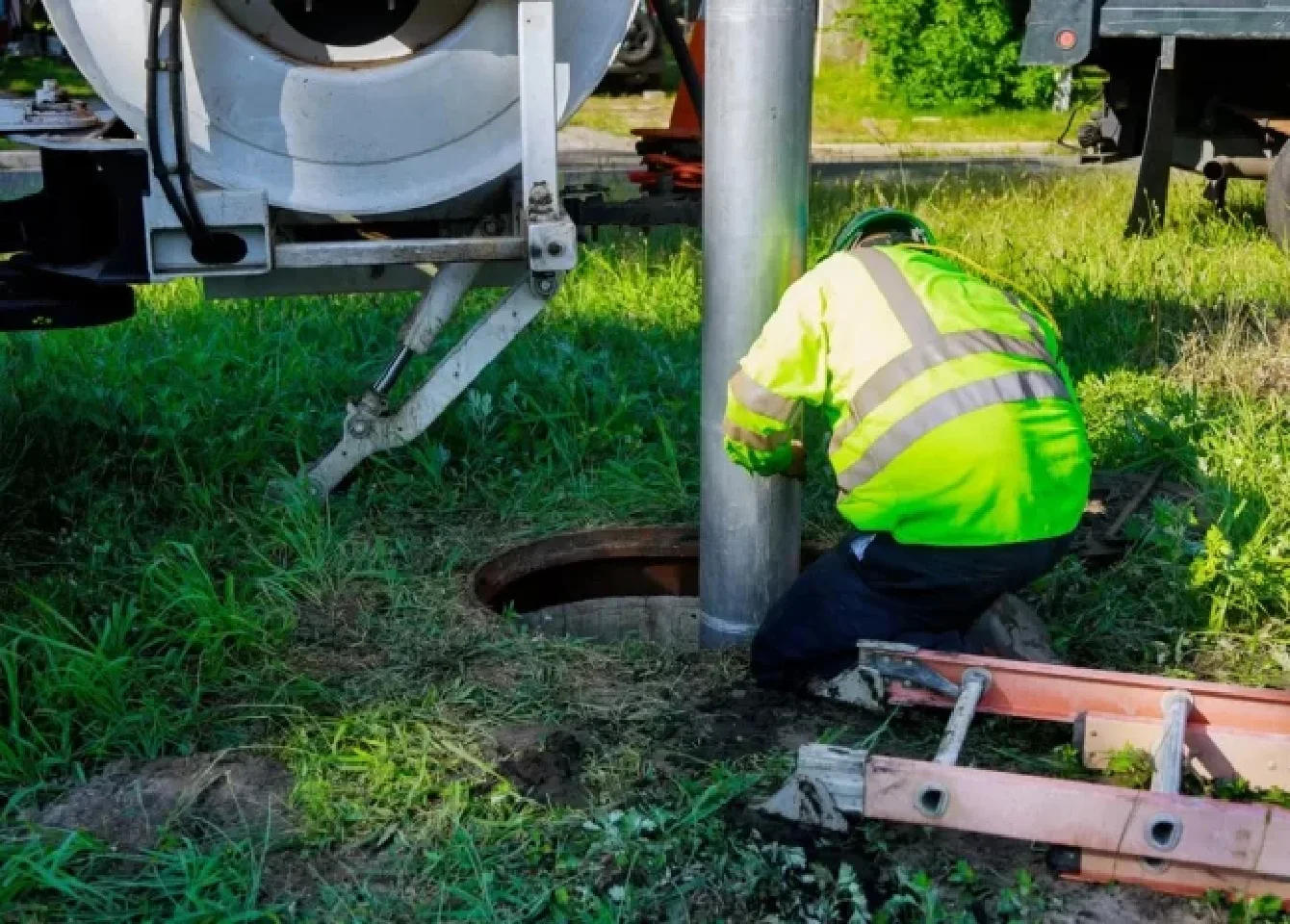 Septic tank pumping operation — technician holding pump line in the Okanagan